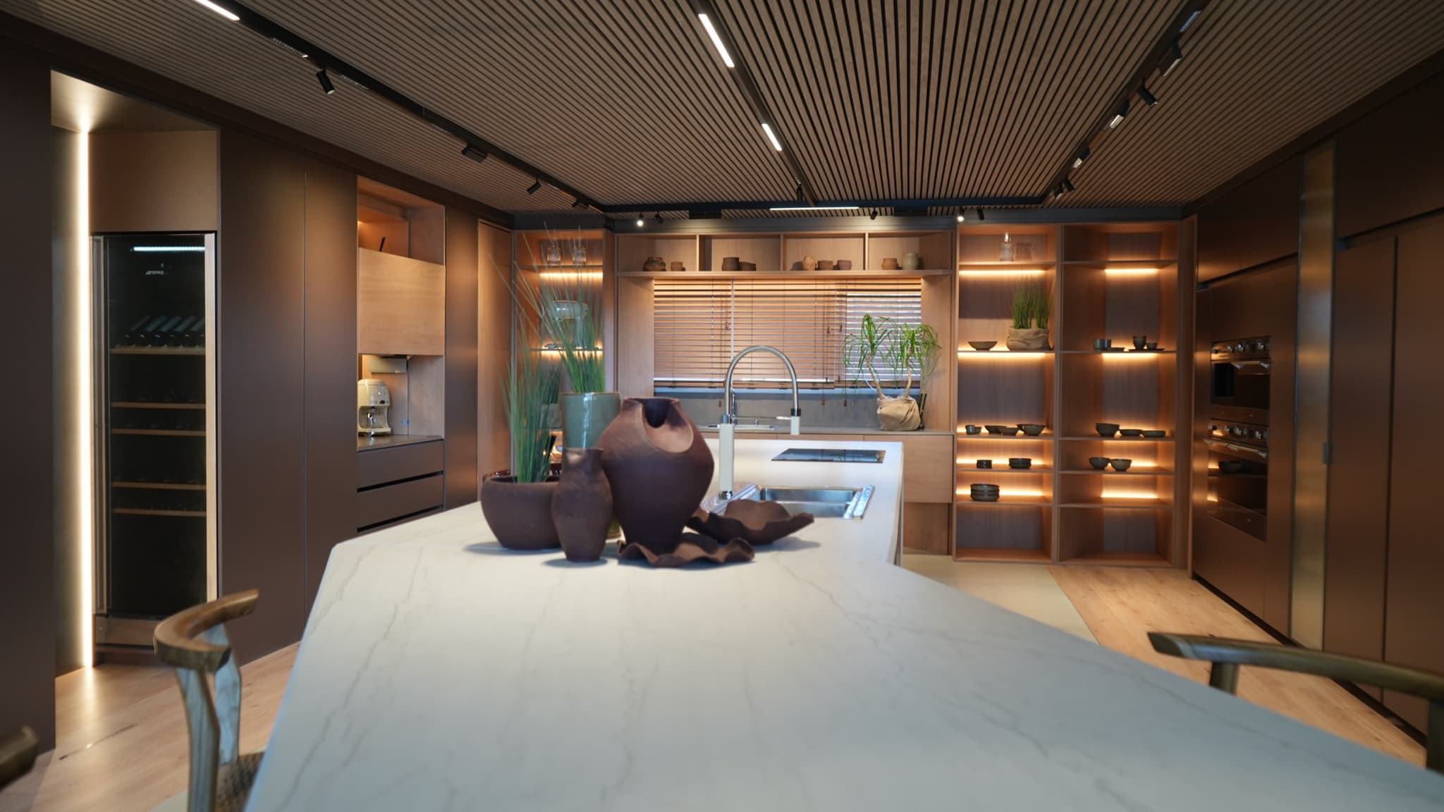 Cocina con isla de mármol y estantería iluminada