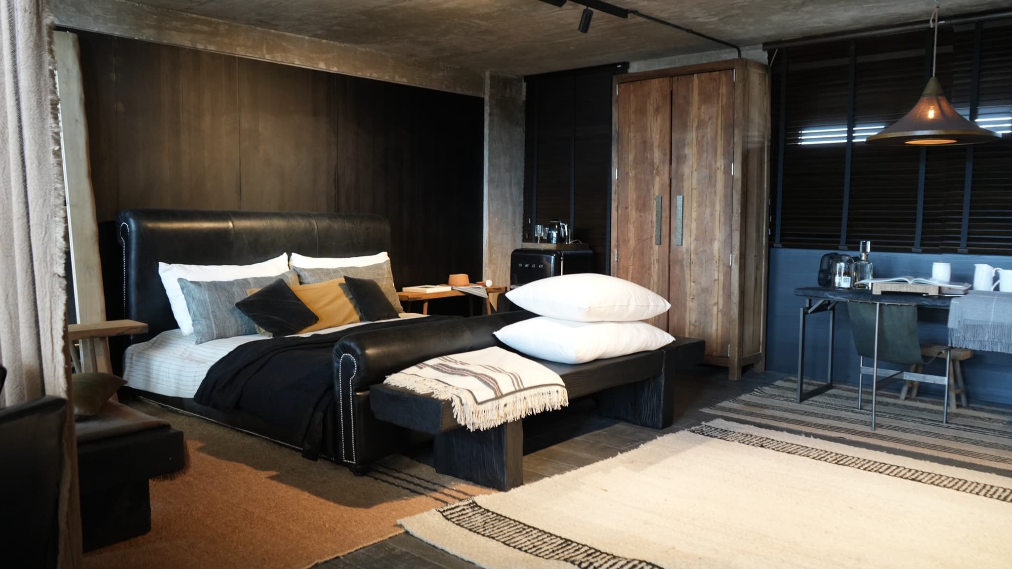 Dormitorio con cabecera de cuero y textiles naturales