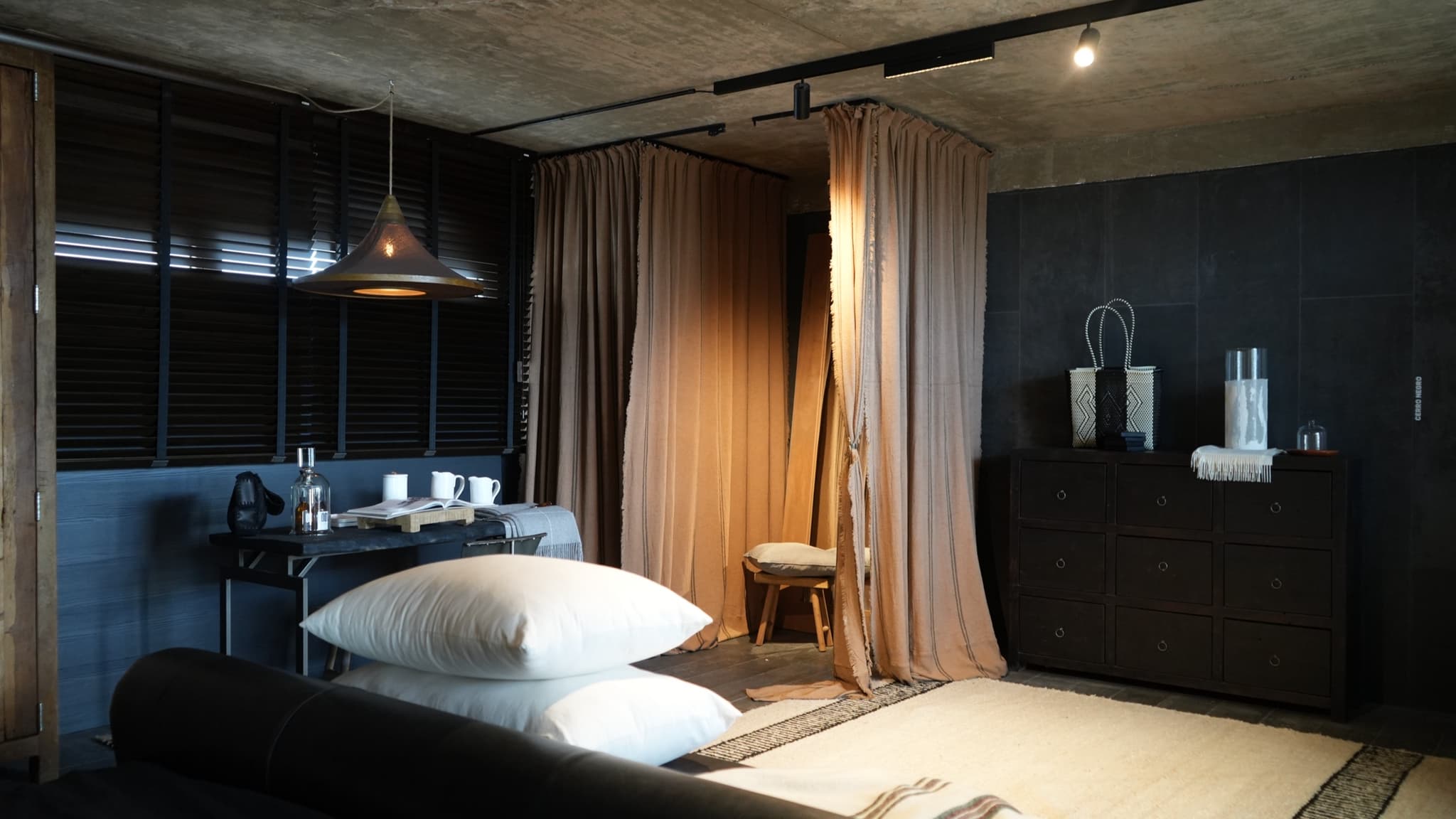 Dormitorio con cortinado de lino y cómoda oscura